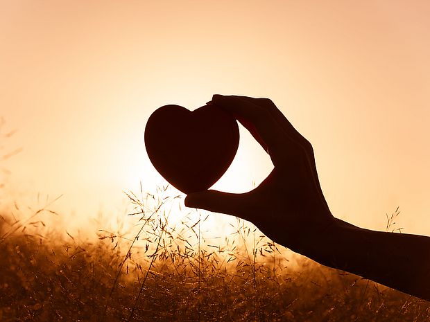 Bild Förderer werden, Hand hält eine Herzform vorm Sonnenuntergang