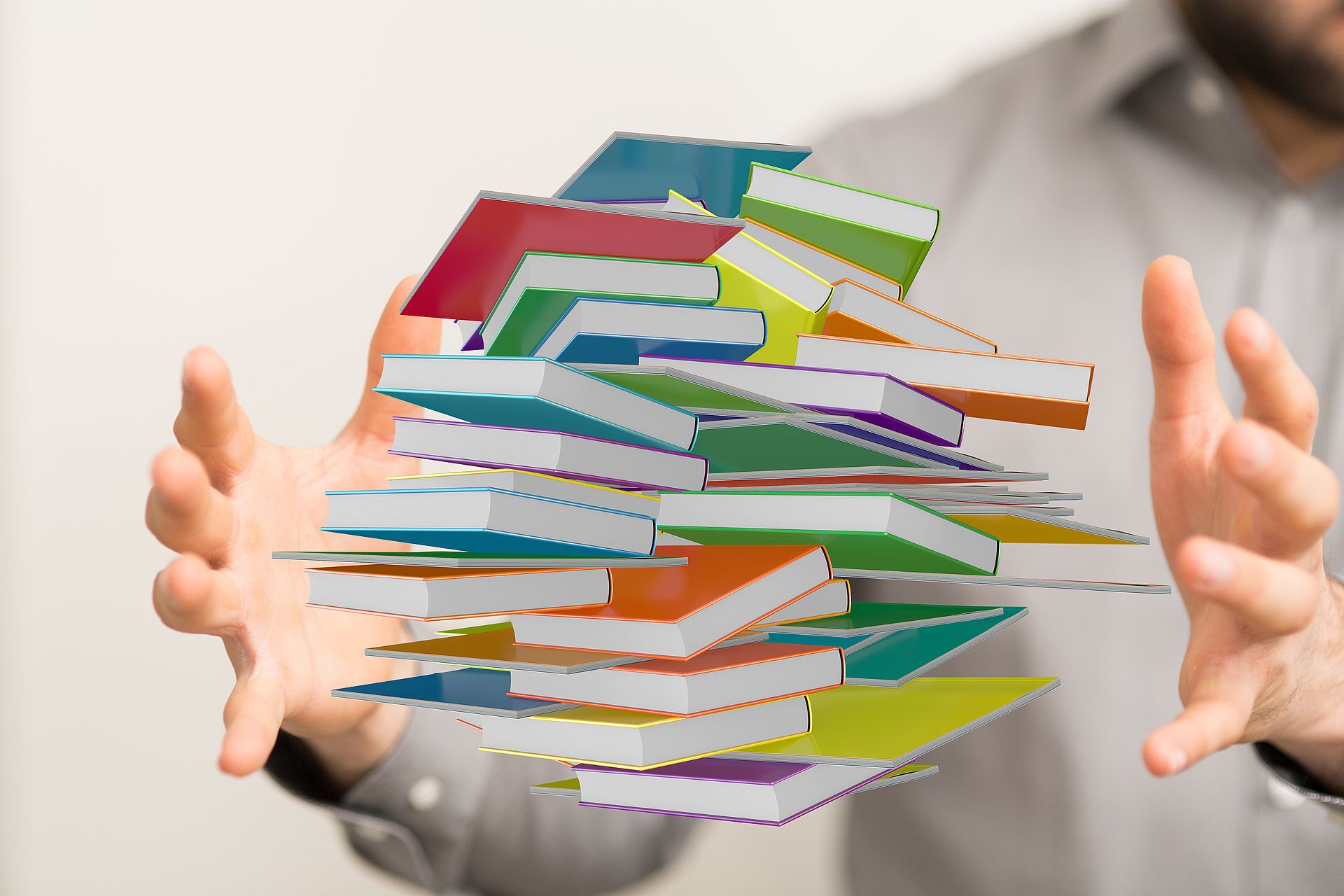 Bild Materialien, zwischen zwei Händen schweben mehrere bunte Bücher Bild Materialien, zwischen zwei Händen schweben mehrere bunte Bücher
